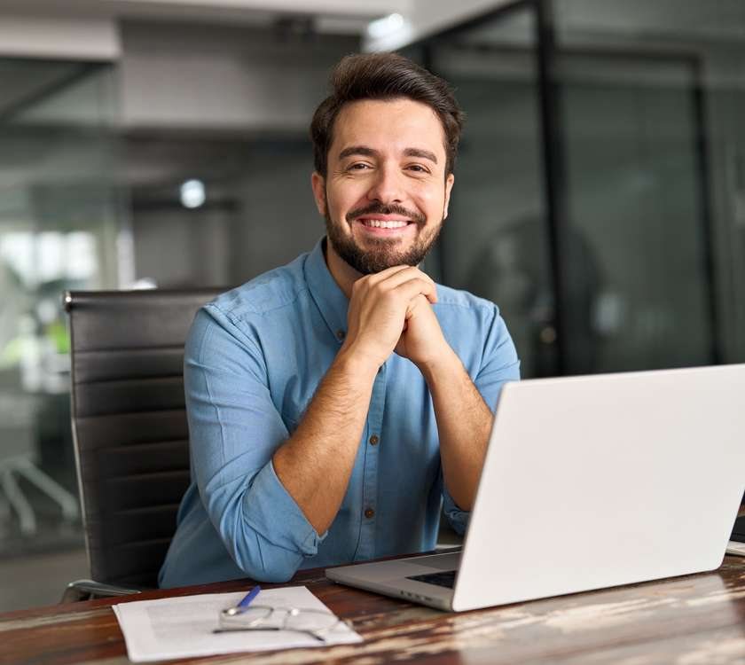 A smiling man at his laptop
